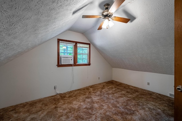 additional living space featuring a textured ceiling, carpet flooring, visible vents, a ceiling fan, and vaulted ceiling