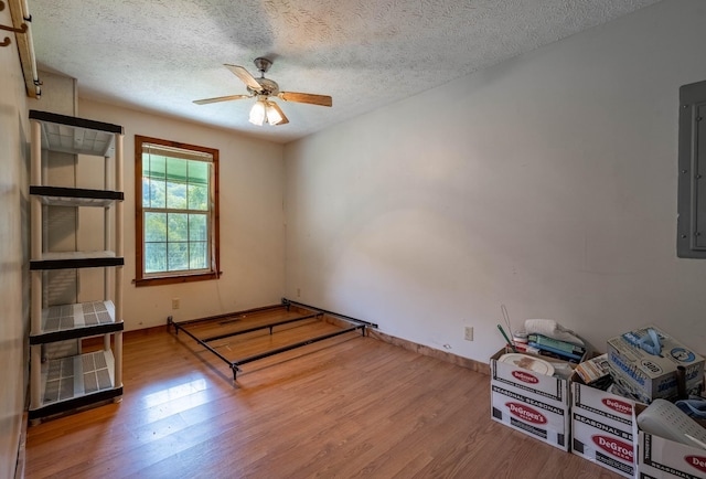 unfurnished room featuring ceiling fan, a textured ceiling, baseboards, and wood finished floors