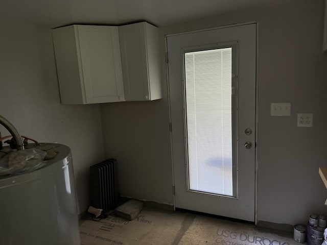 laundry room with radiator and water heater