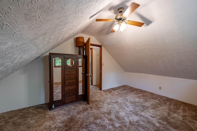 additional living space with carpet floors, lofted ceiling, a textured ceiling, and a ceiling fan