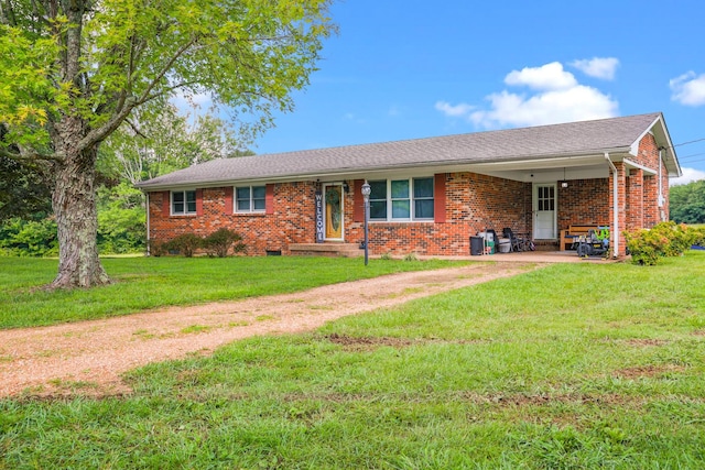 ranch-style home with brick siding, a shingled roof, driveway, a carport, and a front yard