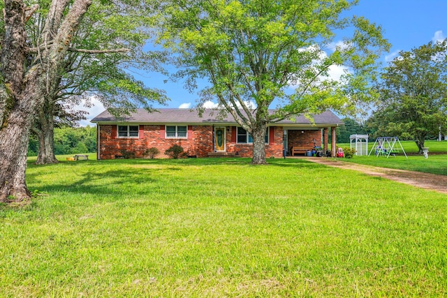 single story home featuring a playground, brick siding, and a front yard