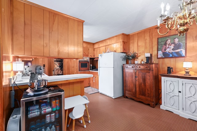 kitchen with oven, carpet floors, white refrigerator, and kitchen peninsula