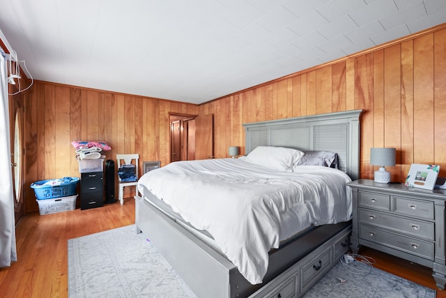 bedroom with wood walls and hardwood / wood-style flooring