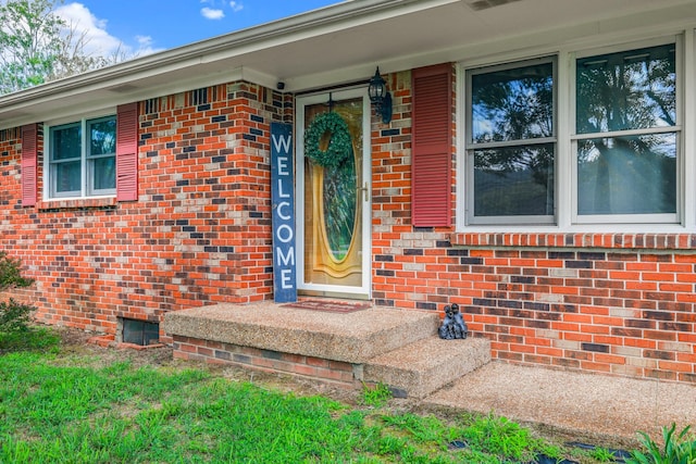 doorway to property featuring brick siding