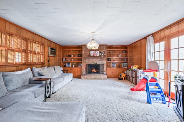 living area featuring carpet floors, a fireplace, wood walls, and built in features