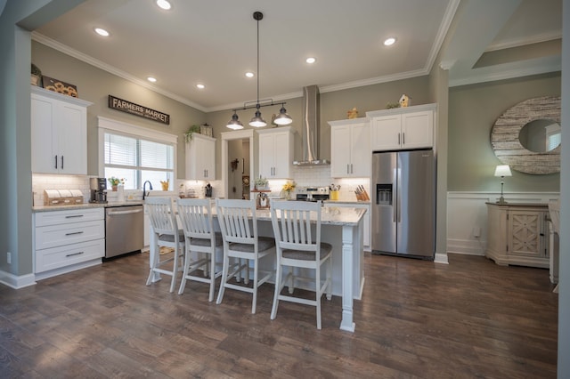 kitchen featuring white cabinets, dark hardwood / wood-style flooring, stainless steel appliances, and wall chimney range hood