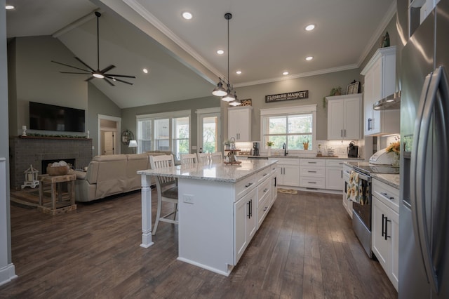 kitchen featuring a fireplace, appliances with stainless steel finishes, white cabinetry, and a kitchen island