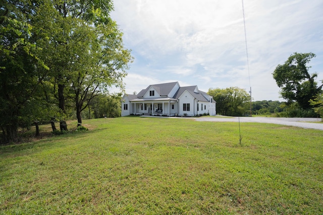 cape cod-style house featuring a porch and a front lawn