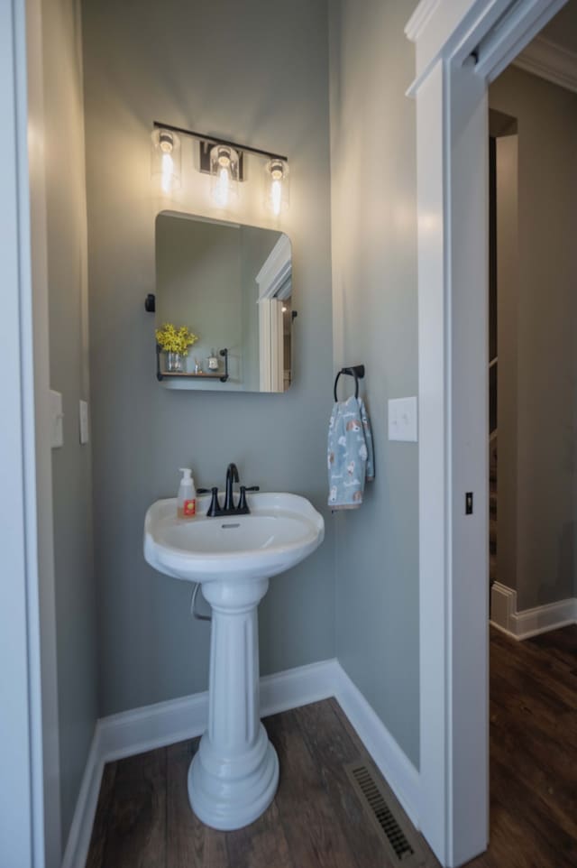 bathroom with wood-type flooring and crown molding