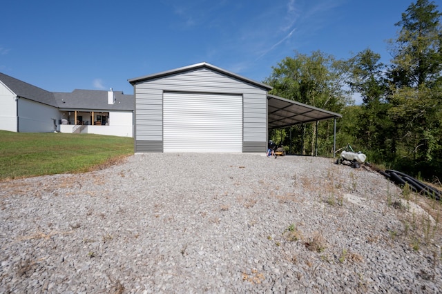 garage with a carport and a lawn