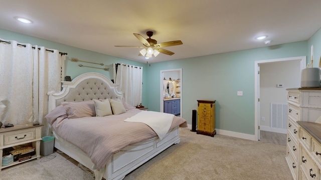 bedroom featuring light carpet, ensuite bath, and ceiling fan