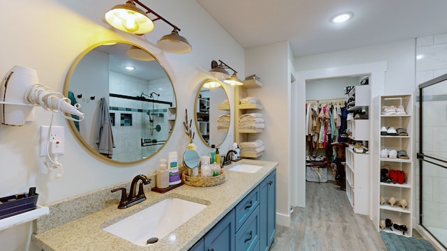 bathroom featuring an enclosed shower, hardwood / wood-style floors, and double vanity