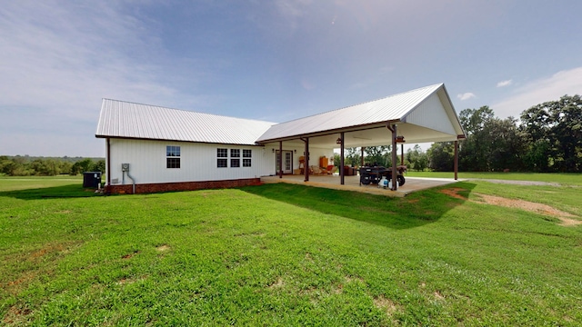 back of house featuring a lawn and a patio area