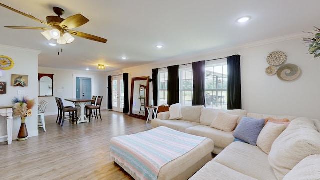 living room featuring light hardwood / wood-style floors, ornamental molding, and ceiling fan