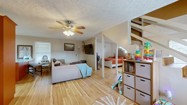 living room with plenty of natural light, a textured ceiling, light hardwood / wood-style flooring, and ceiling fan