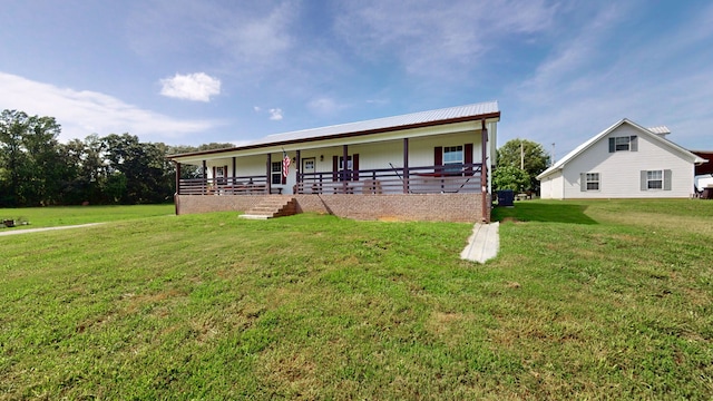 rear view of house with covered porch and a yard