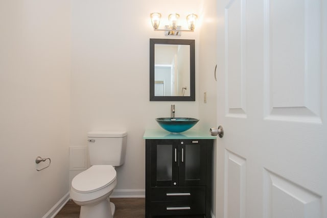 bathroom with vanity, toilet, and hardwood / wood-style floors