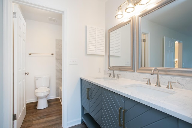 bathroom featuring wood-type flooring, toilet, and double sink vanity