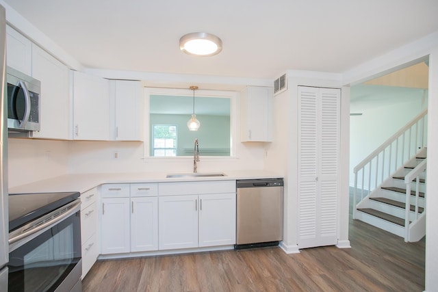 kitchen with sink, white cabinetry, hardwood / wood-style flooring, and stainless steel appliances