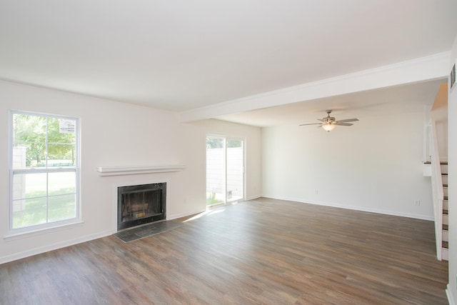 unfurnished living room featuring dark hardwood / wood-style flooring and ceiling fan