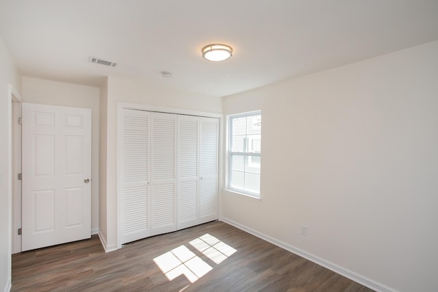 unfurnished bedroom featuring a closet and hardwood / wood-style flooring