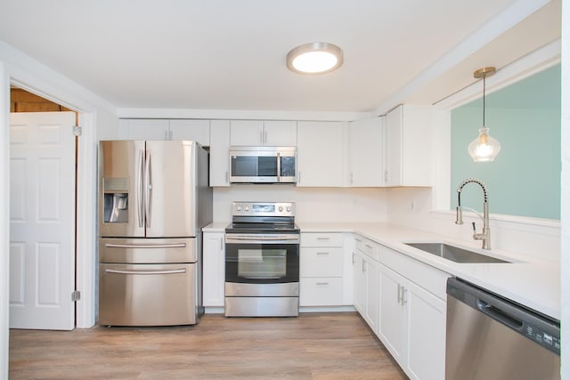 kitchen with white cabinetry, sink, appliances with stainless steel finishes, and light wood-type flooring