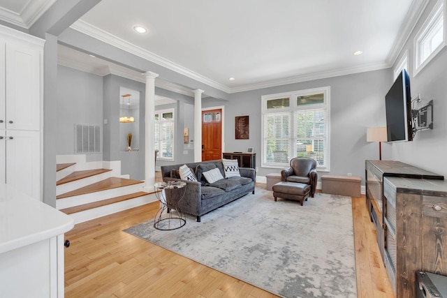 living room with ornamental molding, light hardwood / wood-style floors, and ornate columns