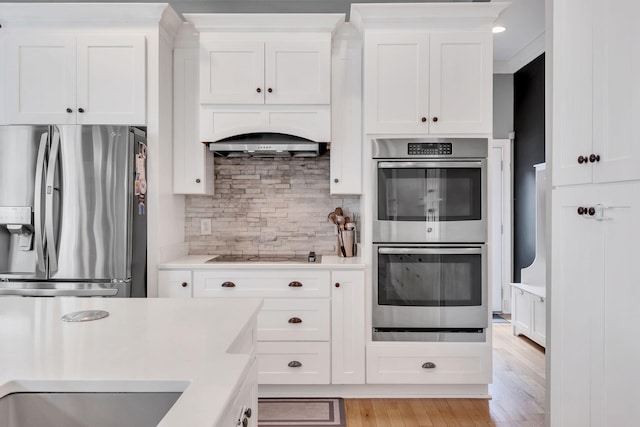 kitchen featuring tasteful backsplash, stainless steel appliances, and white cabinets