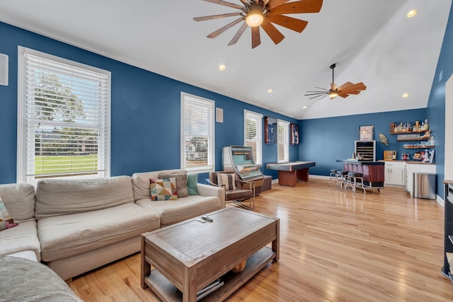 living room with ceiling fan, lofted ceiling, and light hardwood / wood-style flooring