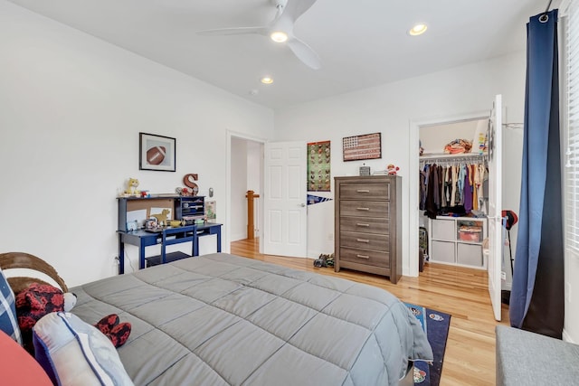 bedroom with wood-type flooring, a spacious closet, ceiling fan, and a closet