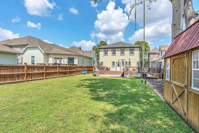 view of yard featuring a wooden deck and a trampoline