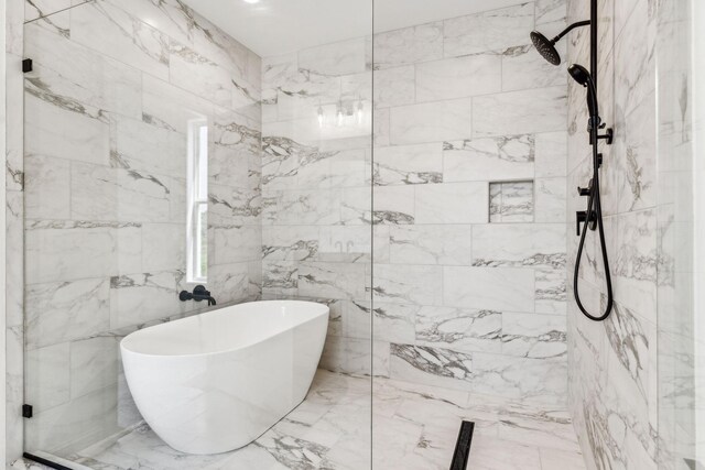 bathroom with tile patterned flooring, tile walls, and a tile shower