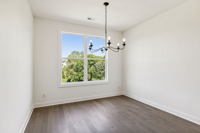 unfurnished dining area featuring a wealth of natural light, wood-type flooring, and a chandelier