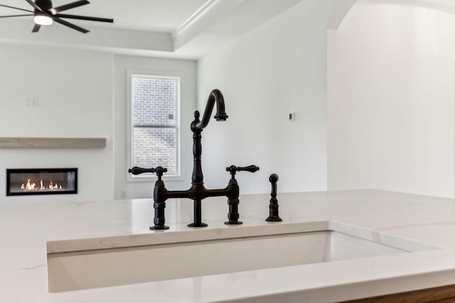 interior details with a glass covered fireplace, a sink, and arched walkways