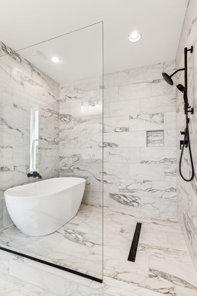 bathroom featuring tile walls and a tile shower