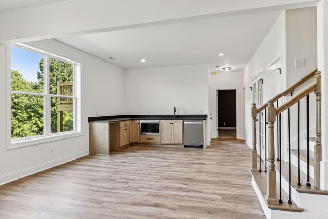 kitchen with light hardwood / wood-style floors, appliances with stainless steel finishes, sink, and light brown cabinets