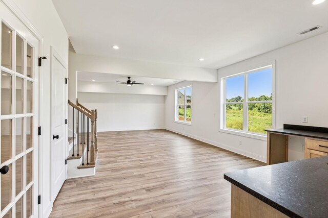 unfurnished living room featuring ceiling fan and light hardwood / wood-style flooring