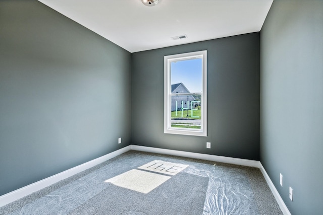 unfurnished room featuring carpet, visible vents, and baseboards