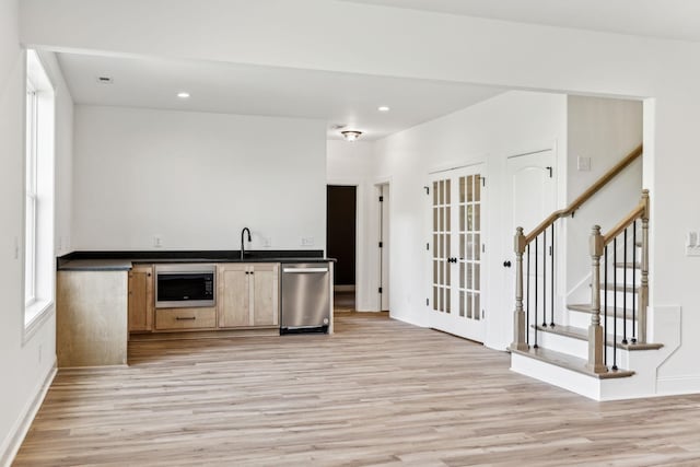 bar featuring stairs, stainless steel dishwasher, light wood-style flooring, and built in microwave