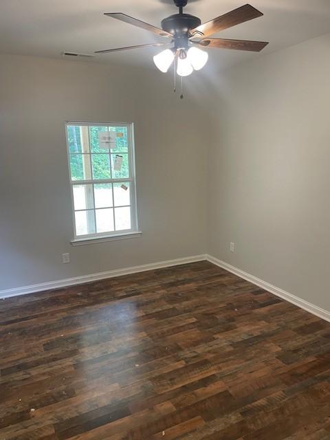 unfurnished room featuring dark hardwood / wood-style flooring and ceiling fan