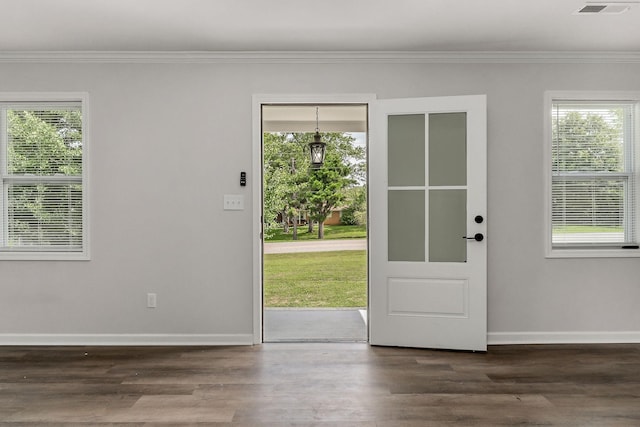 doorway to outside with dark wood-type flooring, ornamental molding, and a wealth of natural light