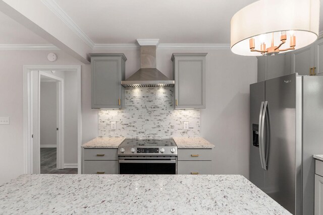 kitchen featuring tasteful backsplash, stainless steel appliances, wall chimney range hood, gray cabinets, and wood-type flooring