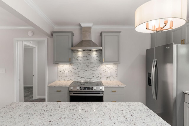 kitchen with gray cabinets, appliances with stainless steel finishes, tasteful backsplash, light stone countertops, and wall chimney exhaust hood