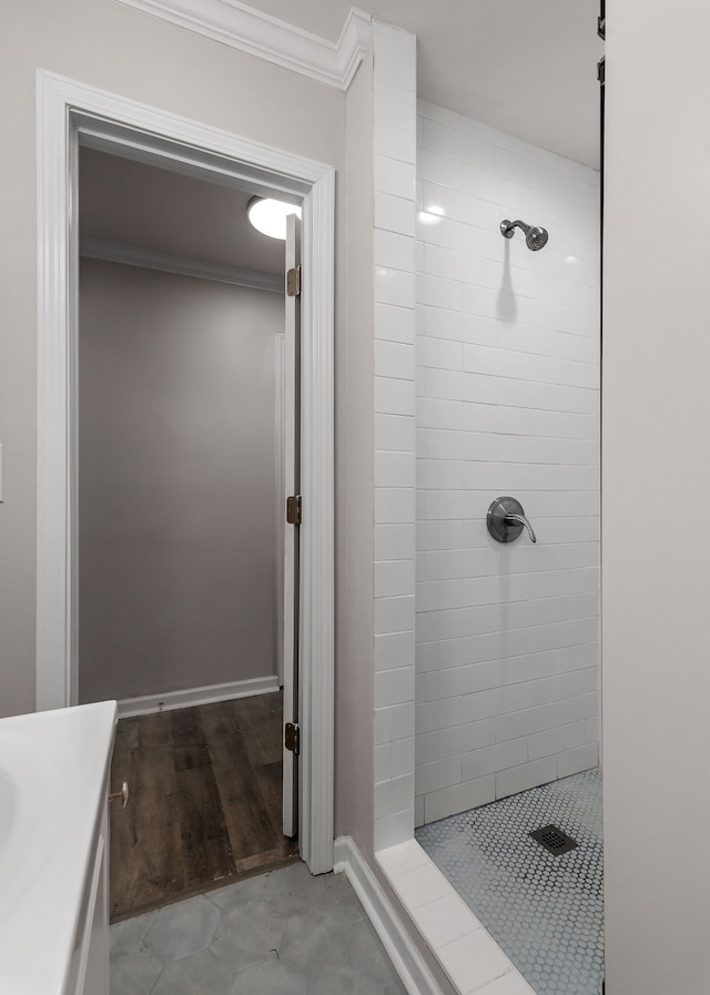 bathroom with vanity, crown molding, a tile shower, and hardwood / wood-style floors