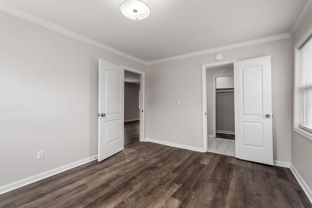 unfurnished bedroom featuring a closet, hardwood / wood-style floors, and ornamental molding