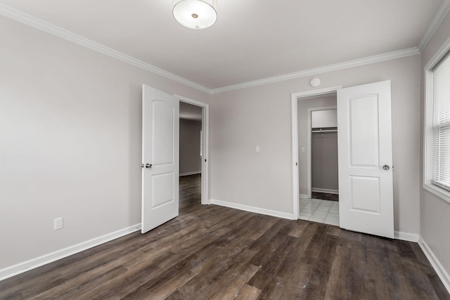 unfurnished bedroom with crown molding and dark wood-type flooring