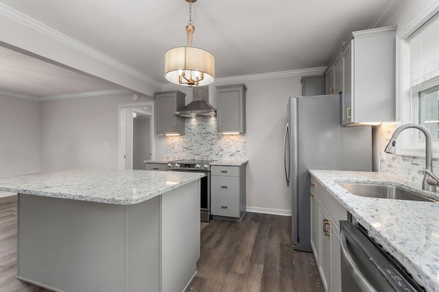 kitchen featuring gray cabinets, appliances with stainless steel finishes, pendant lighting, sink, and wall chimney range hood