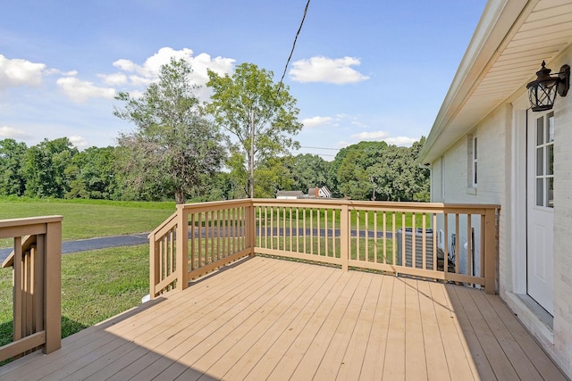 wooden terrace featuring a yard