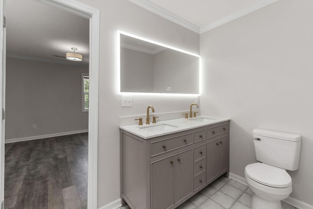 bathroom with crown molding, vanity, and toilet